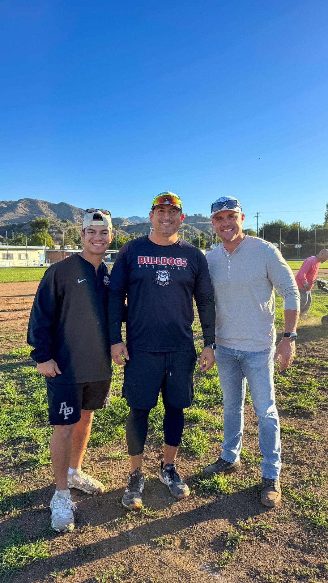 Three community leaders standing at Sutherland Fields with the San Gabriel mountains behind them.