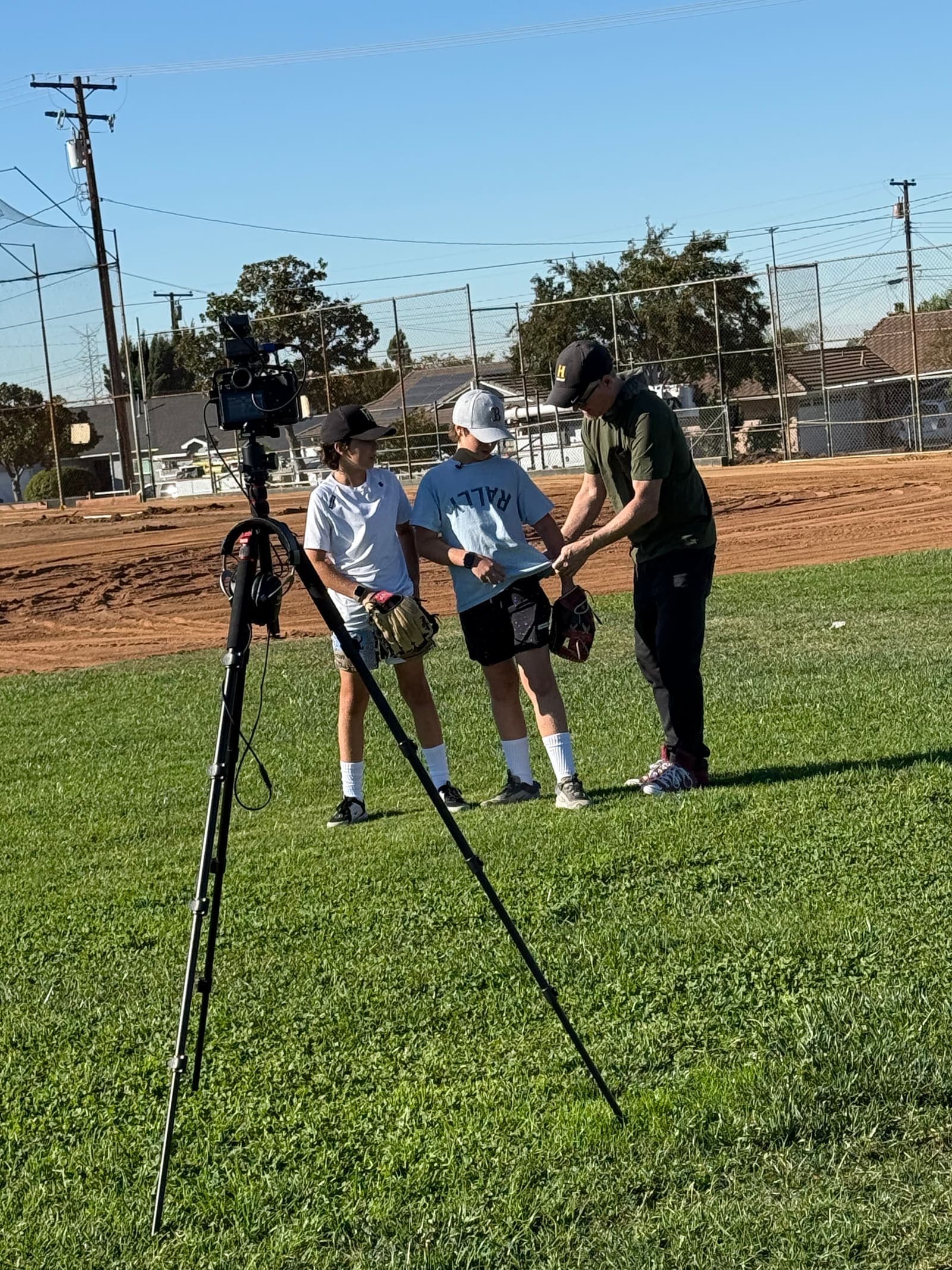 Young players in the outfield at Sutherland Fields, gloves in hand.